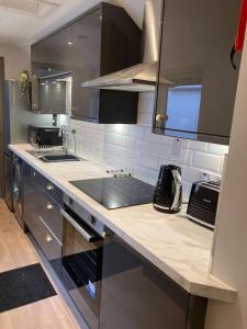 a kitchen with a sink and a counter top at Stunning Coastal Retreat in Carrickfergus