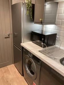 a kitchen with a washing machine and a refrigerator at Stunning Coastal Retreat in Carrickfergus