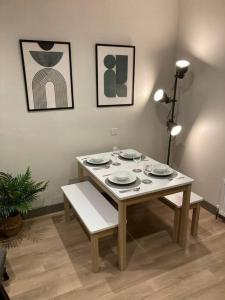 una mesa con platos en una habitación con pinturas en Stunning Coastal Retreat, en Carrickfergus