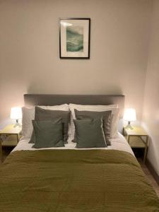 a bedroom with a bed with pillows and two lamps at Stunning Coastal Retreat in Carrickfergus +16 photos