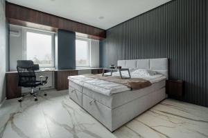 a bedroom with a bed and a desk and a chair at Mickiewicza Prestige Residence with Parking by Rentujemy Łódź City Center in Łódź