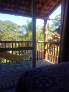 - une chambre avec vue sur une terrasse couverte dotée d'un lit dans l'établissement Alma Surf House, à Boicucanga