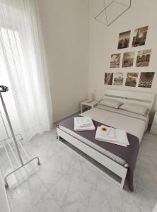 una camera bianca con un letto e un vassoio di cibo sopra di Casa di Susy a Napoli