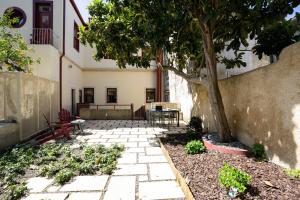 a patio with a tree and a table and chairs at Entre Ruas Apartments in Coimbra