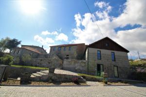 una antigua casa de piedra con una pared de piedra en Casas do Campo da Moita en Baião