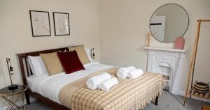 a bedroom with a bed with towels on it at Coney Cottage in Porthcawl
