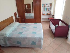a bedroom with a bed and a chair at Casa Mimosa - appartamento vacanze sul Lago di Como in Sorico