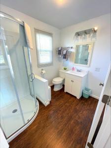 uma casa de banho com um chuveiro, um WC e um lavatório. em Hillcrest Inn & Motel em Rapid River