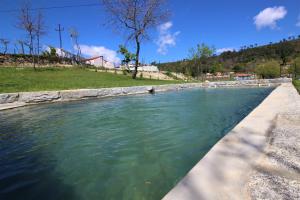 una piscina de agua junto a una carretera en Casas do Campo da Moita en Baião