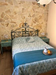 um quarto com uma cama com uma parede de pedra em www luabierzo em Molinaseca