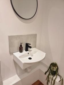 a white bathroom with a sink and a mirror at 28 ExcellentStays - Heathrow - 5 Bedroom House in Stanwell