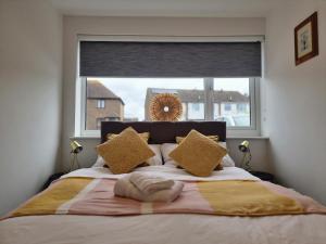 - une chambre avec un grand lit et une grande fenêtre dans l'établissement 28 ExcellentStays - Heathrow - 5 Bedroom House, à Stanwell