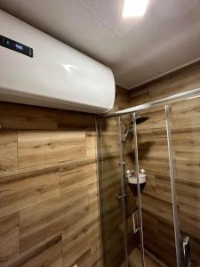 a bathroom with wooden walls and a shower stall at Apartman Petrov in Donji Milanovac