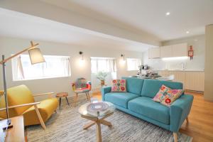 un soggiorno con divano blu e una cucina di Porto Unique Cosy Duplex a Porto