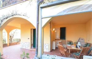 einen externen Blick auf eine Terrasse mit einem Tisch und Stühlen in der Unterkunft Stunning Home In Diano Calderina With 2 Bedrooms in Diano Castello