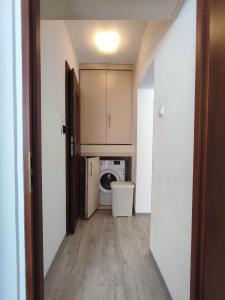 un couloir menant à une buanderie avec lave-linge et sèche-linge dans l'établissement Komfortowy Apartament w Kłodzku, à Kłodzko