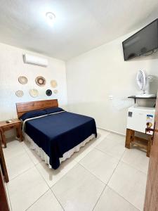 a bedroom with a bed and a flat screen tv at Pousada da Praia in Paraty
