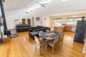 sala de estar con mesa y sofá en Acacia Lakehouse en Goon Nure