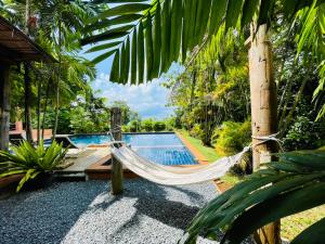 a hammock in front of a swimming pool at Bamboo Hideaway, Bungalows with Pool and Kitchen in Ko Mak