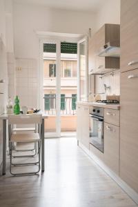 uma cozinha com armários brancos e uma mesa em Mr. Brown - Camillo em Roma