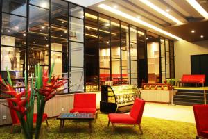 eine Lobby mit roten Stühlen und einem Tisch in einem Gebäude in der Unterkunft Sparks Life Jakarta, ARTOTEL Curated in Jakarta