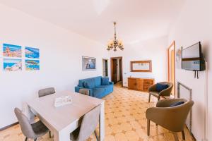 a living room with a dining table and a blue couch at Appartamento Emma in Villa Laura in Scala