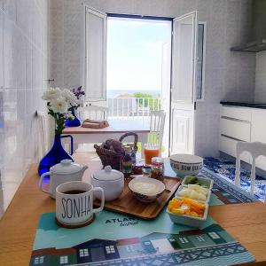 einen Tisch mit einem Tablett mit Essen und einer Tasse Kaffee in der Unterkunft Farol Guesthouse in Angra do Heroísmo