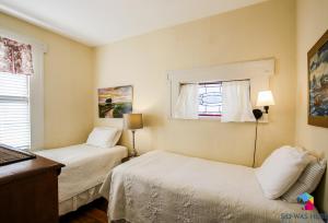 ein kleines Schlafzimmer mit 2 Betten und einem Fenster in der Unterkunft Forsyth Park Off Street Parking, Hist Savannah Lwr in Savannah