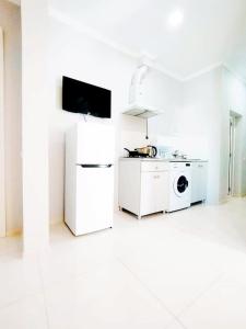 a white kitchen with a stove and a microwave at Dream House Ureki in Ureki