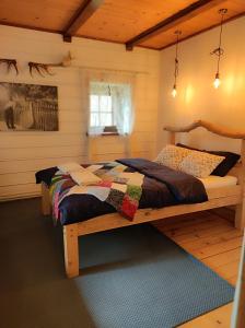 sypialnia z drewnianym łóżkiem z kołdrą w obiekcie Gniazdo w Felicjanowie w Uniejowie