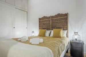 セビリアにあるAlohaMundi Castellarのベッドルーム1室(大型ベッド1台、大型ヘッドボード付)