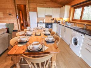 a kitchen with a wooden table with chairs and appliances at Kingfisher Lodge in Market Rasen