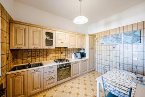 una cocina con armarios de madera y fregadero en Appartamento Emma in Villa Laura, en Scala