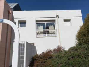 - un bâtiment blanc avec une fenêtre sur le côté dans l'établissement T1 confortable situé 100m plage des Minimes, à La Rochelle