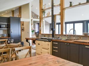 a kitchen with black cabinets and a wooden table at The Coach House in Blencogo