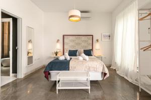 a white bedroom with a large bed and a table at Indulge en Sevilla Zaragoza in Seville