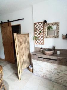 uma casa de banho com uma porta de madeira e um espelho em L'instant... em Marolles-sous-Lignières