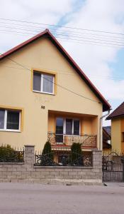una casa amarilla con una valla delante de ella en Apartmány Lúčky 30, en Lúčky