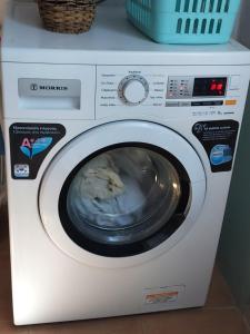 a white washing machine with its door open at Green Oasis 3 in Lámira
