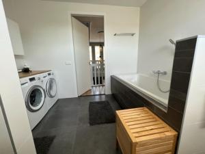 uma casa de banho com uma máquina de lavar roupa e uma máquina de lavar e secar roupa em Casa Hermosa em Sassenheim