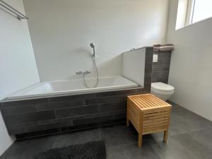 a bathroom with a bath tub and a toilet at Casa Hermosa in Sassenheim