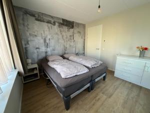 uma cama com duas almofadas num quarto em Casa Hermosa em Sassenheim
