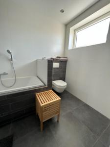 a bathroom with a toilet and a bath tub and a window at Casa Hermosa in Sassenheim