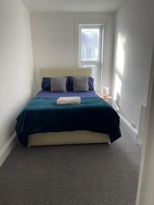1 dormitorio con 1 cama grande en una habitación blanca en Room in Gloucester Road 4, en Bristol