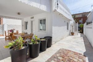 a patio with a table and some potted plants at Villa Dimarts- a 100m de playa in Gandía