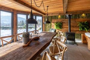 comedor con mesa de madera y chimenea en Dom Beskidy, en Brenna