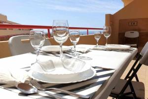 - une table avec des verres à vin et des assiettes sur un balcon dans l'établissement Apartamento Jarmar Puerto Santiago, à Puerto de Santiago