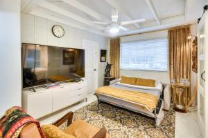 a bedroom with a bed and a clock on the wall at New Smyrna Beach Cottage about 1 Mi to Downtown! in New Smyrna Beach