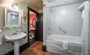 La salle de bains est pourvue d'une baignoire, d'un lavabo et d'une douche. dans l'établissement Le Clos Saint-Louis, à Québec