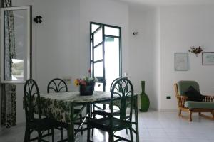 una sala da pranzo con tavolo, sedie e finestra di Villetta Parisi a Mazara del Vallo